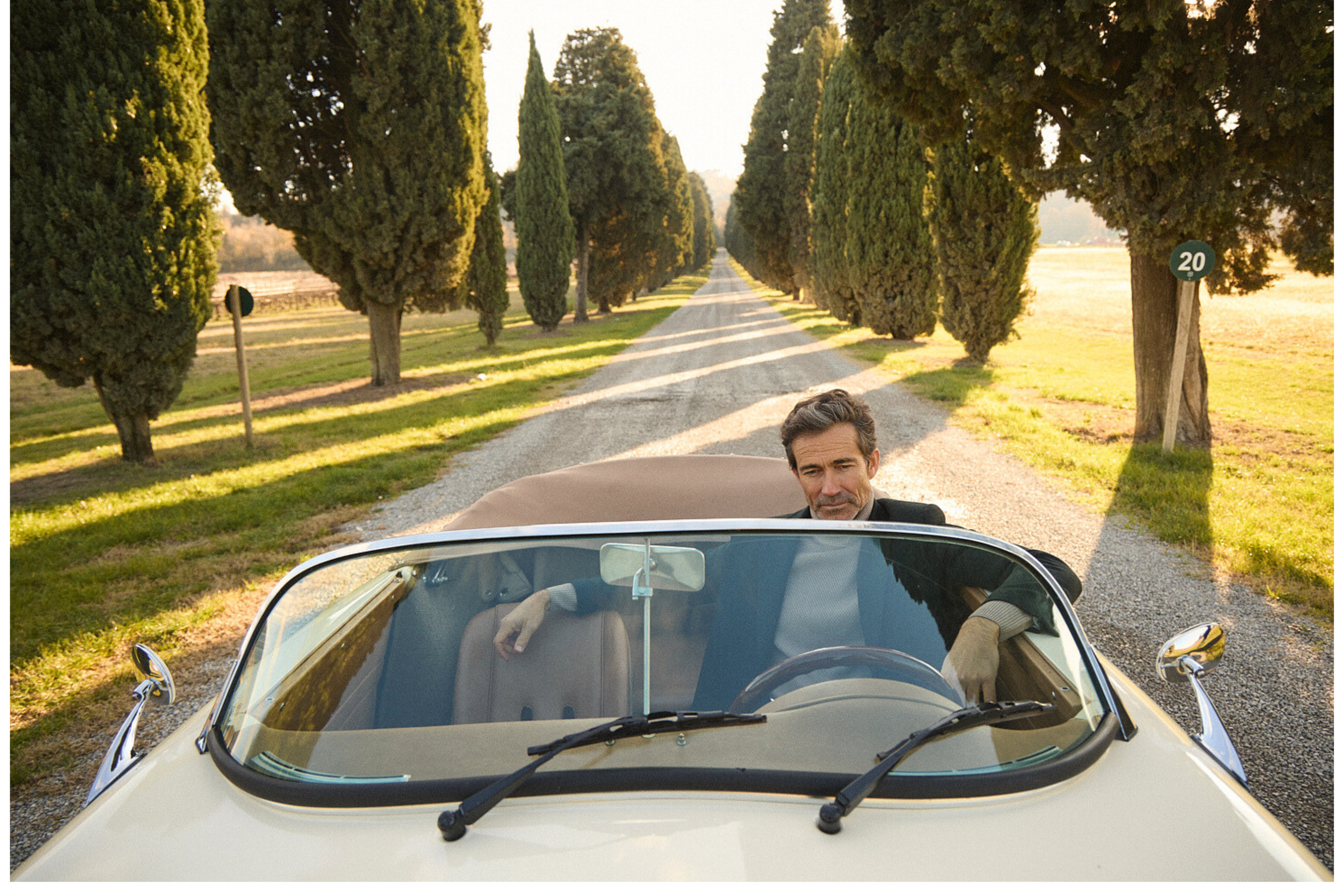 Vintage cabrio αυτοκίνητο διασχίζει δεντρόφυτο χωμάτινο δρόμο στο Roncolo, μέρος της κινηματογραφικής αφήγησης της καμπάνιας Portobello’s Fall–Winter 2026.